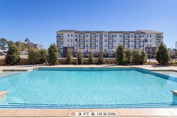 The Reid Apartments in Tucker, GA - Oversized Sparkling Swimming Pool Surrounded By Lush Landscaping